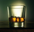Glass half full with liquor and ice