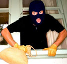 Burglars: We'll turn off the lights for ya. Burglar breaking in a home window.