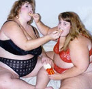 You scratch my mouth, I'll scratch yours. Two fat girls in bras feeding each other