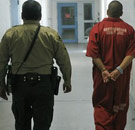 Prisoner and guard walk to jail cell