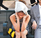 Woman with costume on and holding newspaper over her head