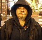 Homeless man staring straight ahead with cigarette in mouth