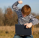 Nothing like being alone in a field with your (online) thoughts! Kid punching a laptop in a field
