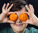 Kid with oranges on his eyes