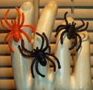Keep the spider senses tingling, ya'll. Halloween spider rings in orange and black on a hand