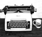 Typewriter with coffee mug next to it