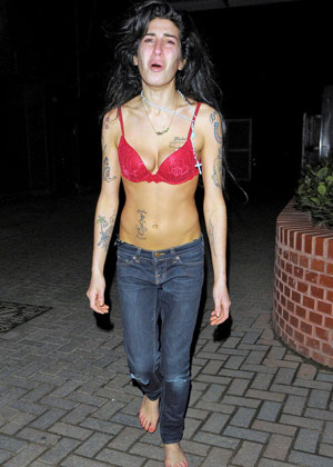 Amy Winehouse in a pink bra and jeans