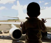 Baby staring at an airplane from in the airport terminal