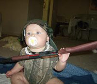 Baby holding a rifle