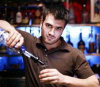 Male bartender pouring a shot