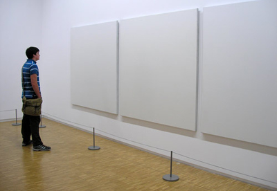 3 blank white pieces of art in a gallery