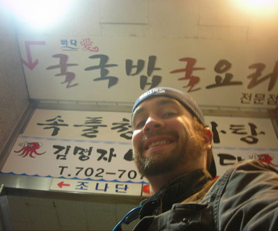 Casey Freeman in front of a Korean sign