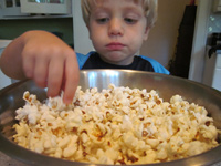 Child eating out of a popcorn bowl
