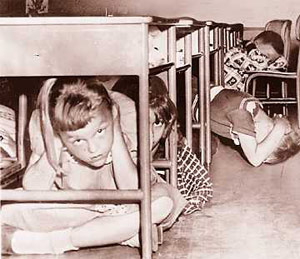 Children under desk for bomb drill during Cold War