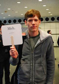 Christopher Poole holding up a 'Meh.' sign