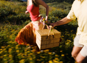 Couple on a picnic in the woods with a picnic basket