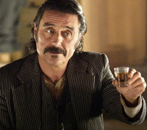 Guy from Deadwood TV show with a whiskey drink in hand