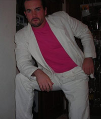 KC in a pink shirt with a white suit