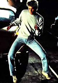 Kevin Bacon dancing in a warehouse