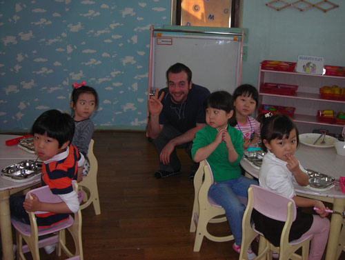 Korean children sitting in a classroom with American teacher