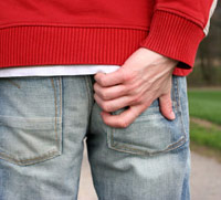Man itching his butt through his jeans