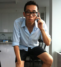 Nerdy Asian guy in glasses on his cell phone