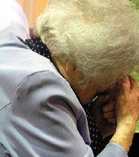 Old woman with her head down in church