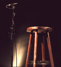 Microphone and stool on stage at open mic comedy night