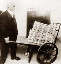 Man pushing a wheelbarrow of cash.