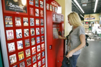 Woman renting a DVD from Redbox.