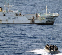 Somali pirates in motorboat approach commercial ship