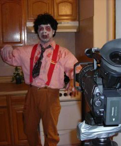 Casey dressed as a zombie in front of a video camera