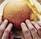 Blind person touching a Braille hamburger bun at McDonald's