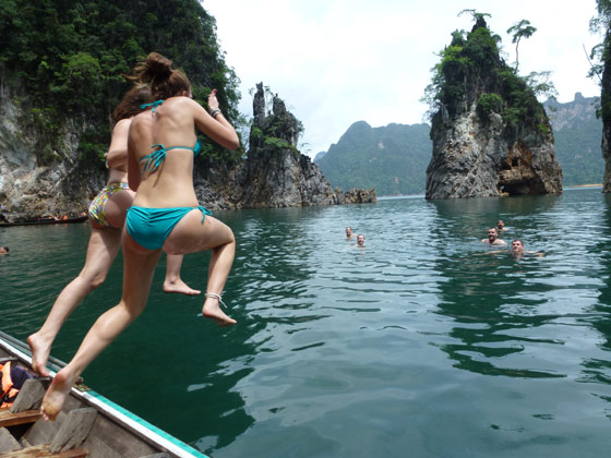 Two girls jumping off a boat in bikinis in Thailand