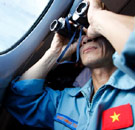 Malaysian official using binoculars to search for missing airplane