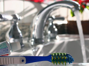 Toothbrush on the sink with water running