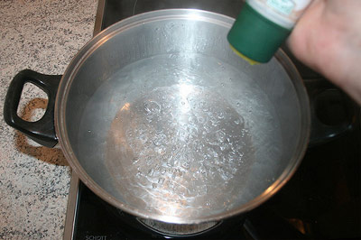 Adding salt to pot of boiling water