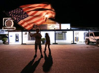 People waving an American flag at night following the death of Osama bin Laden