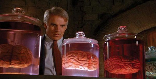 Steve Martin staring at three jars of human brains