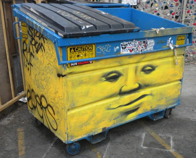 Trash dumpster behind a motel building