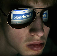 Creepy guy in sunglasses at his computer on Facebook