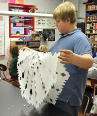 Kid tries to re-fold an origami paper