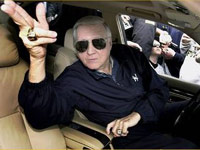 George Steinbrenner making a gun with his fingers from inside a car