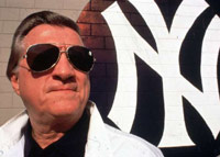 George Steinbrenner next to a Yankees baseball logo