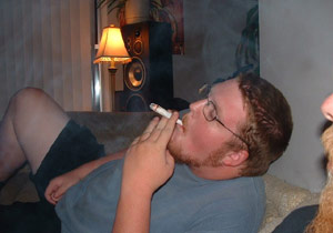 Guy smoking marijuana on the couch