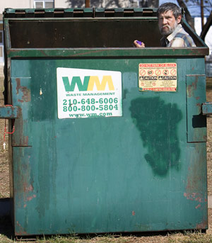 Homeless guy in a trash dumpster