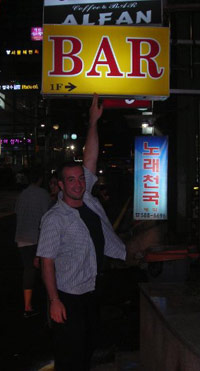 KC pointing to a BAR sign in Korea