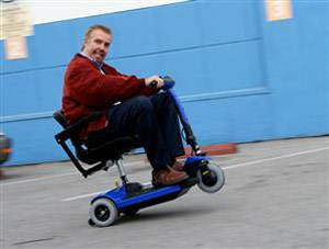 Old man doing a wheelie on a motorized scooter