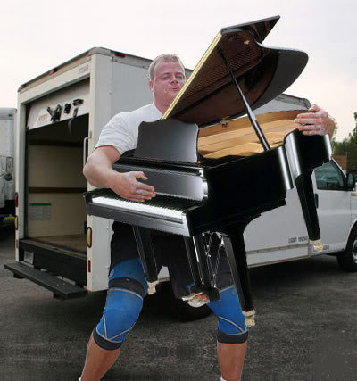 Man moves a piano up stairs by himself