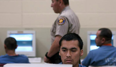 Prisoners using computers with guard watching